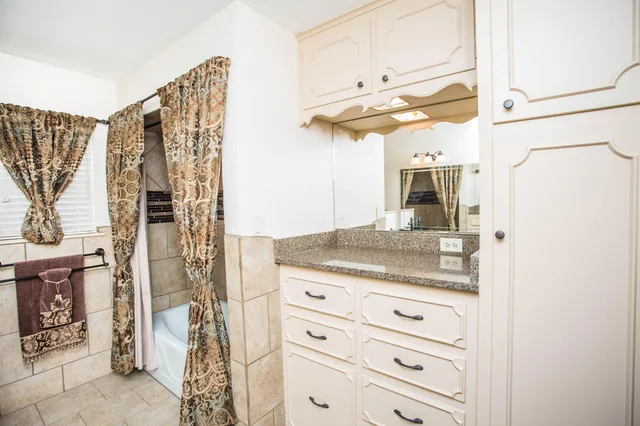 a bathroom with a granite countertop sink and a mirror
