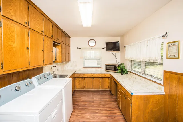 a large white kitchen with a sink and large window