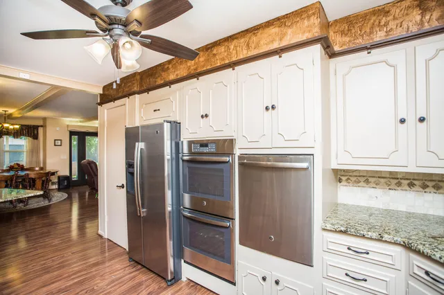 a kitchen with stainless steel appliances granite countertop a refrigerator and a stove