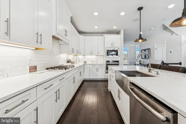 a kitchen with stainless steel appliances sink stove and white cabinets