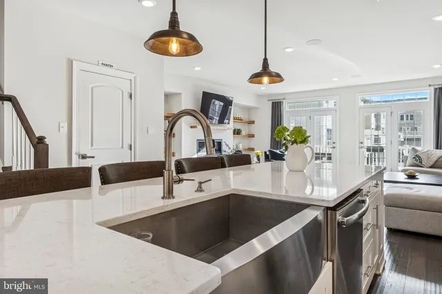 a kitchen with stainless steel appliances granite countertop a sink a stove and a wooden floors