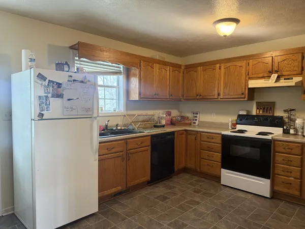 a kitchen with stainless steel appliances granite countertop a stove a sink and a refrigerator