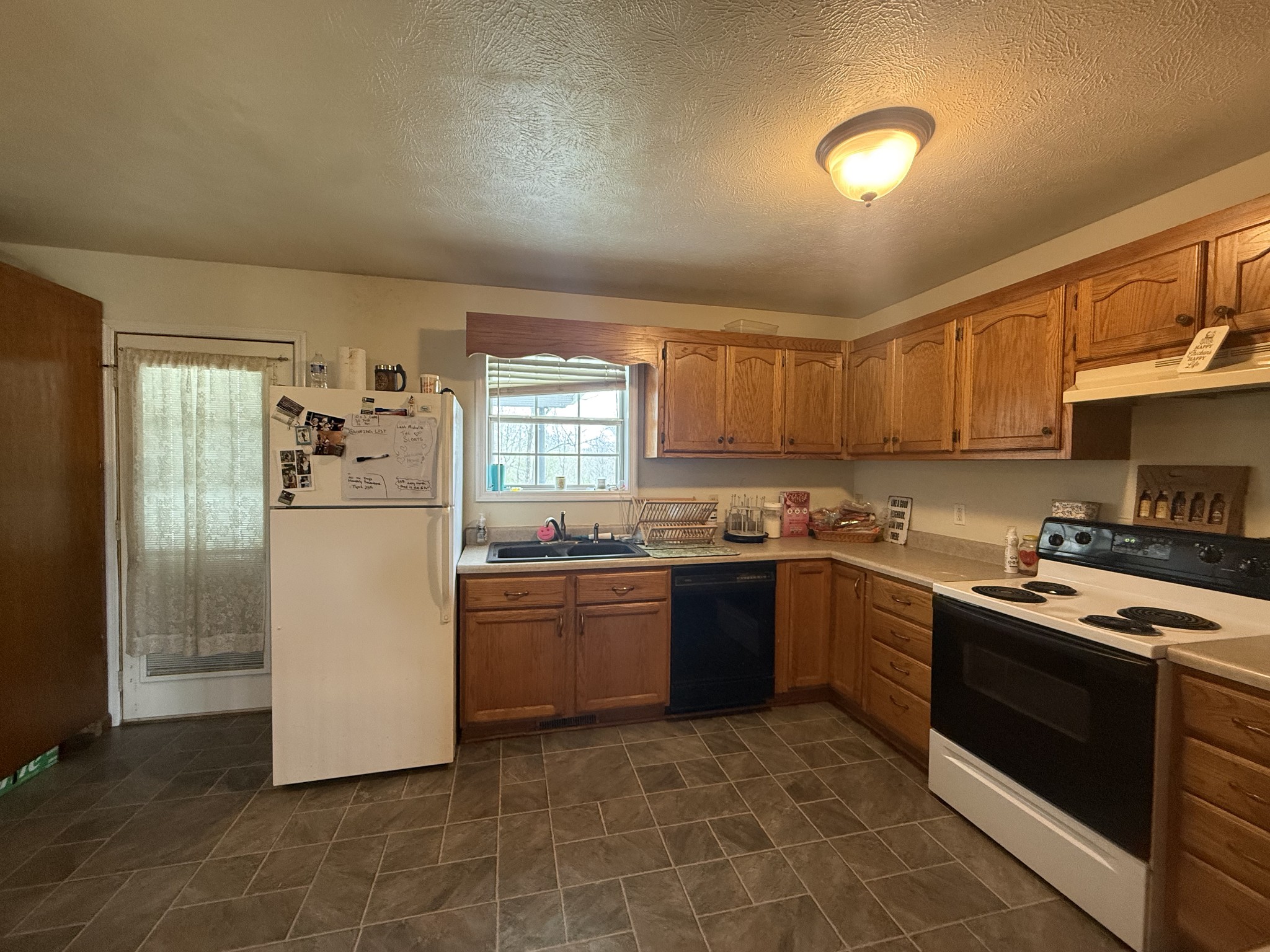 150 Deerwood Road Hohenwald, TN 38462 - Photo 15 of 56 a kitchen with stainless steel appliances granite countertop a stove top oven a sink and a refrigerator