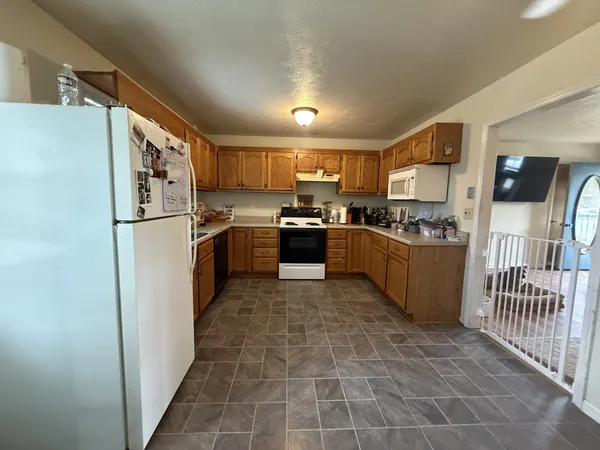 a kitchen with stainless steel appliances granite countertop a stove a sink and a refrigerator