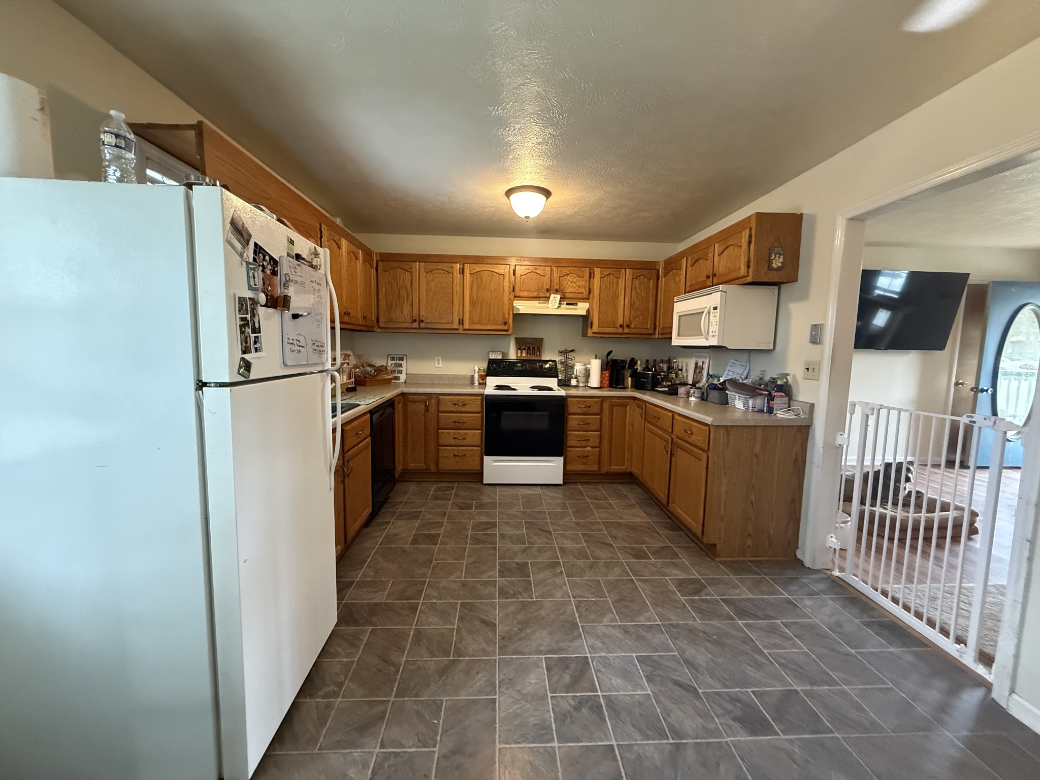 150 Deerwood Road Hohenwald, TN 38462 - Photo 16 of 56 a kitchen with granite countertop a refrigerator a sink a stove top oven and cabinets