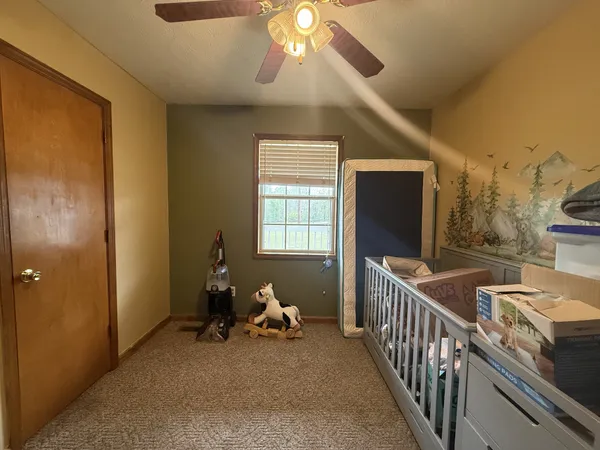 a bedroom with a bed and a flat tv screen on dresser