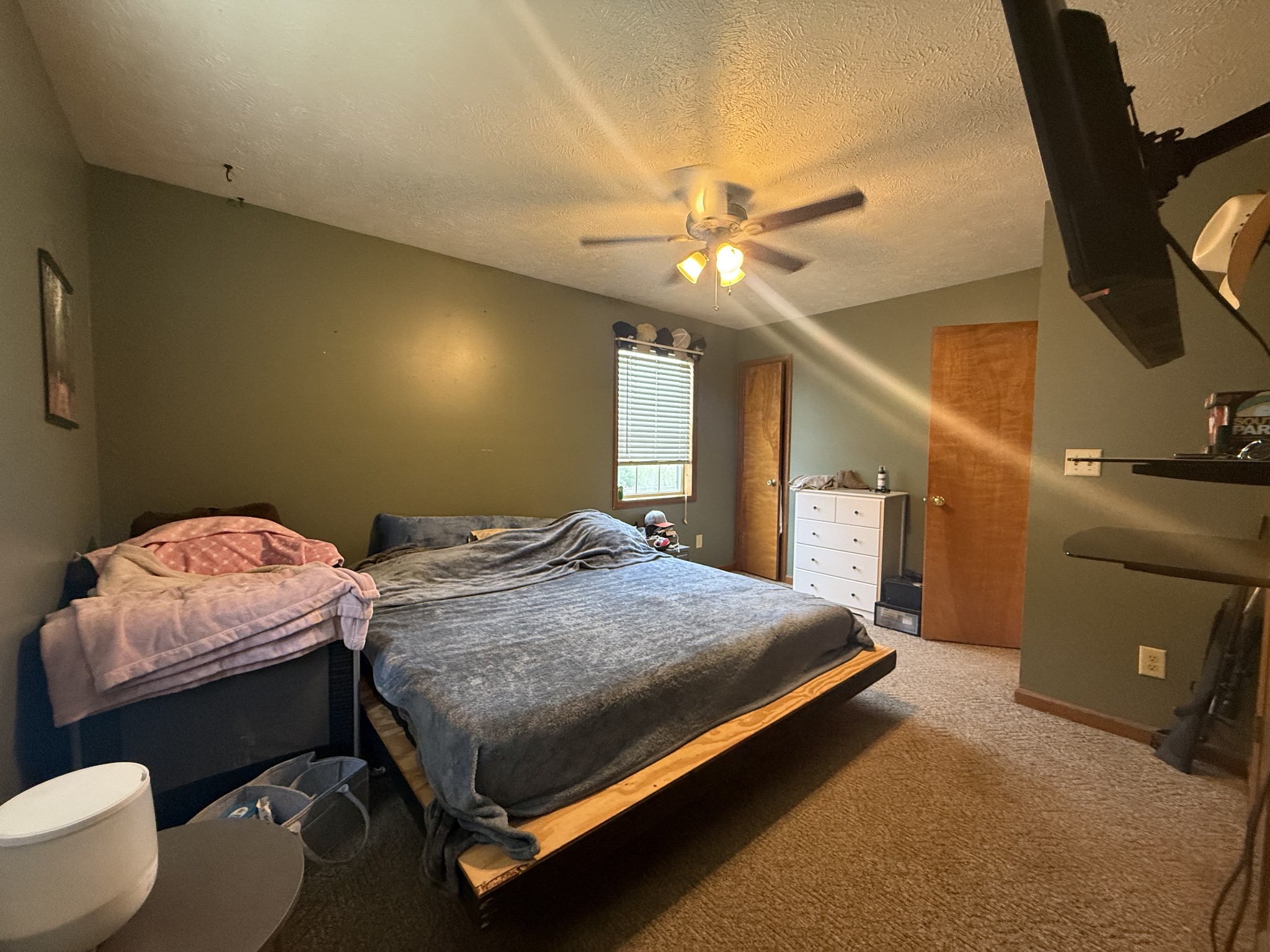 150 Deerwood Road Hohenwald, TN 38462 - Photo 32 of 56 a bedroom with a bed and a chandelier