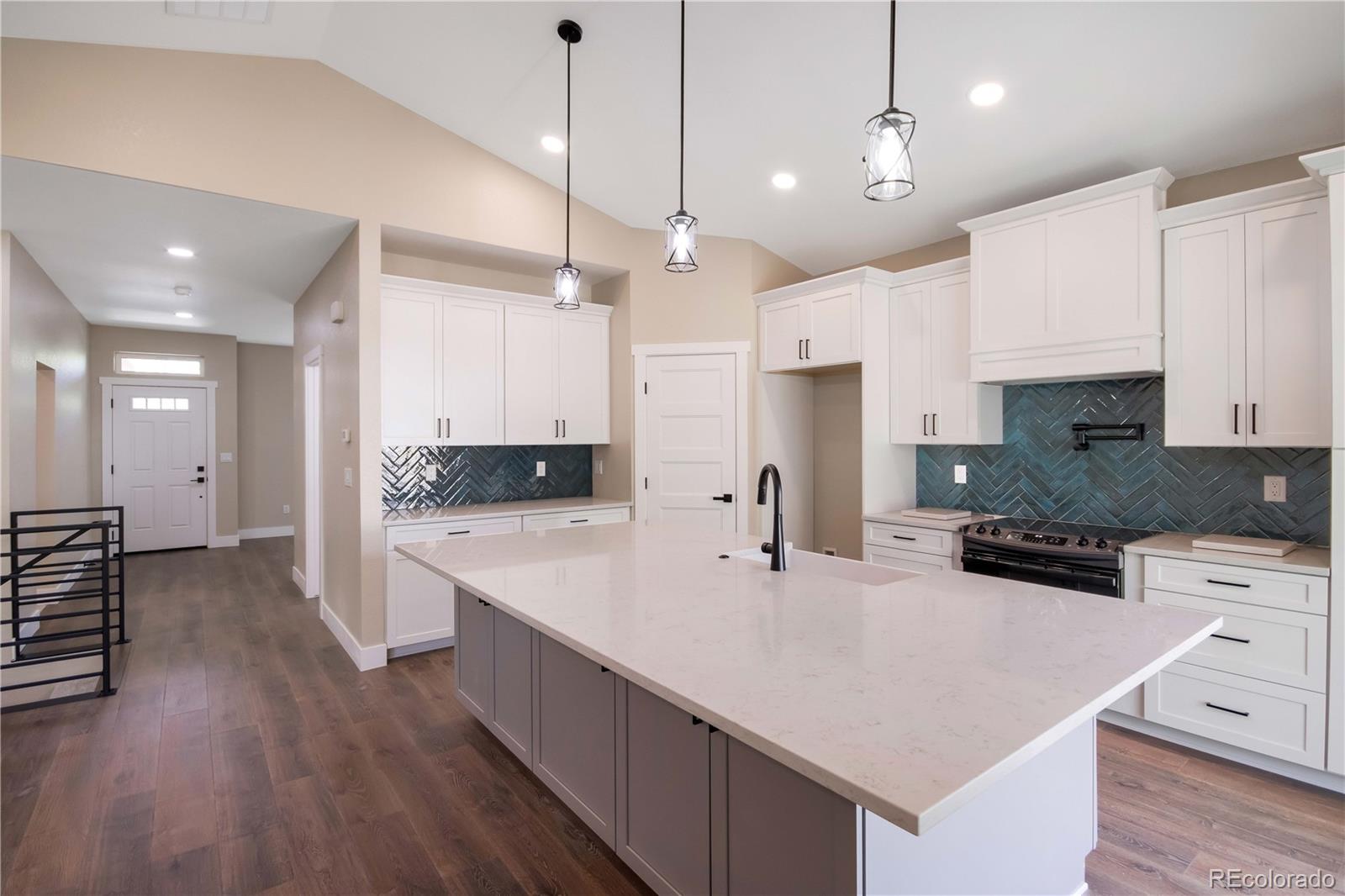 1220 Swainson Road Eaton, CO 80615 - Photo 11 of 35 a kitchen with stainless steel appliances a sink a stove a refrigerator a center island and cabinets