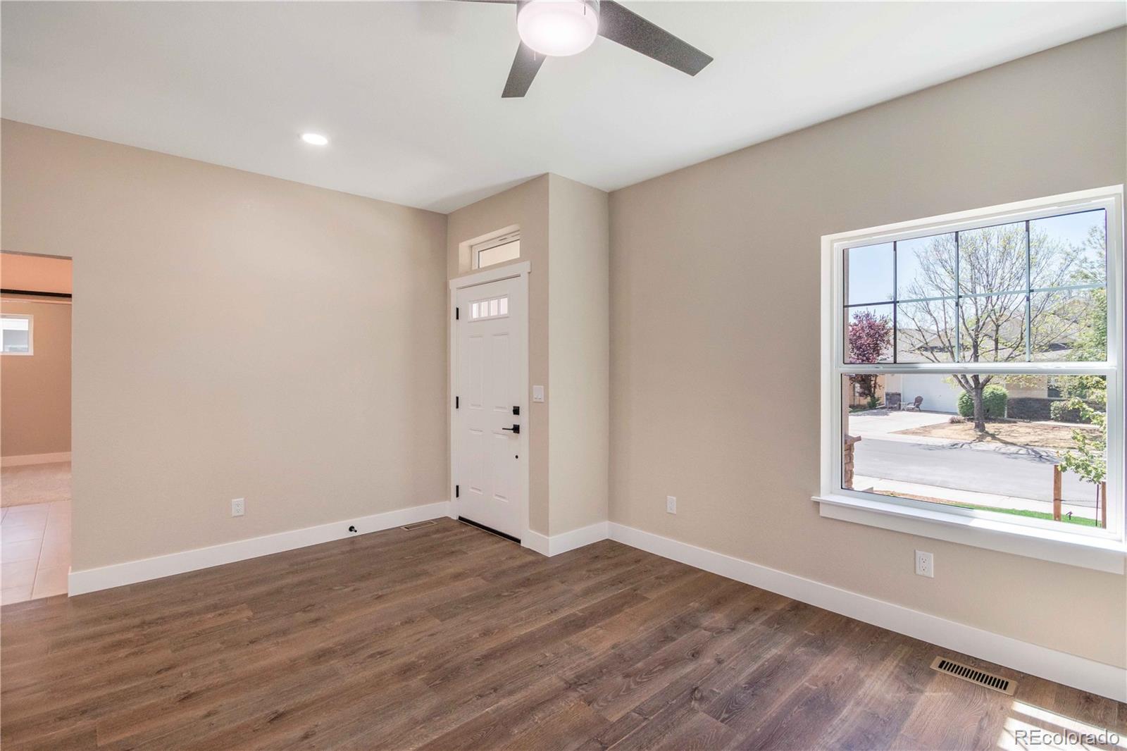 1220 Swainson Road Eaton, CO 80615 - Photo 3 of 35 an empty room with wooden floor and windows