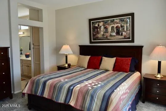 a bedroom with a bed and lamp on dresser