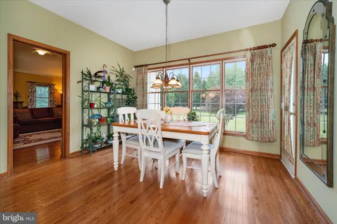 a dining room with furniture window and wooden floor