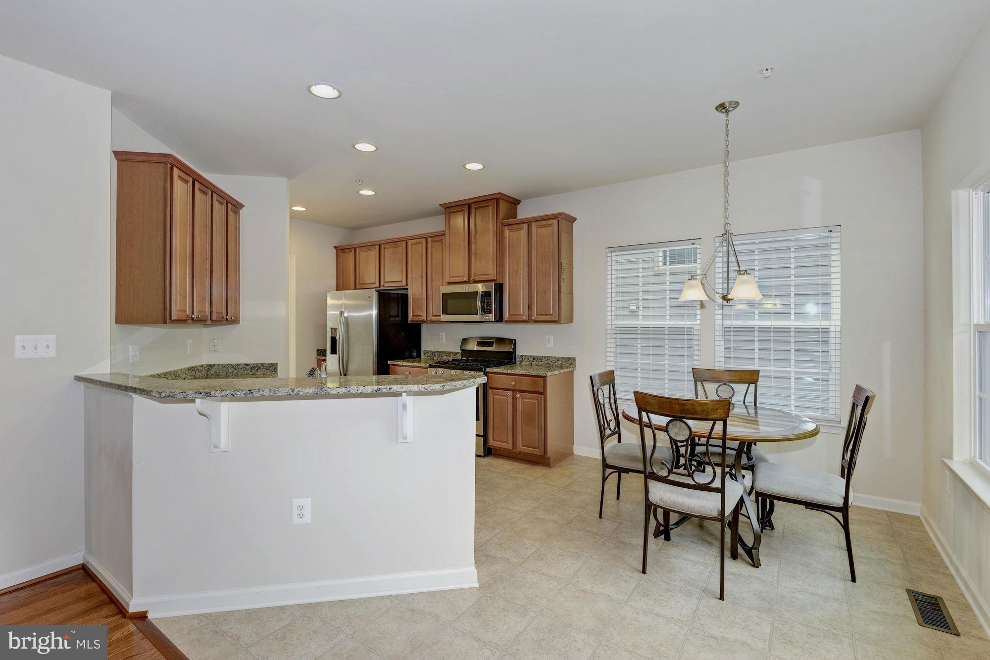 2644 St Marys View Road Accokeek, MD 20607 - Photo 11 of 29 a kitchen with kitchen island a dining table chairs and white cabinets