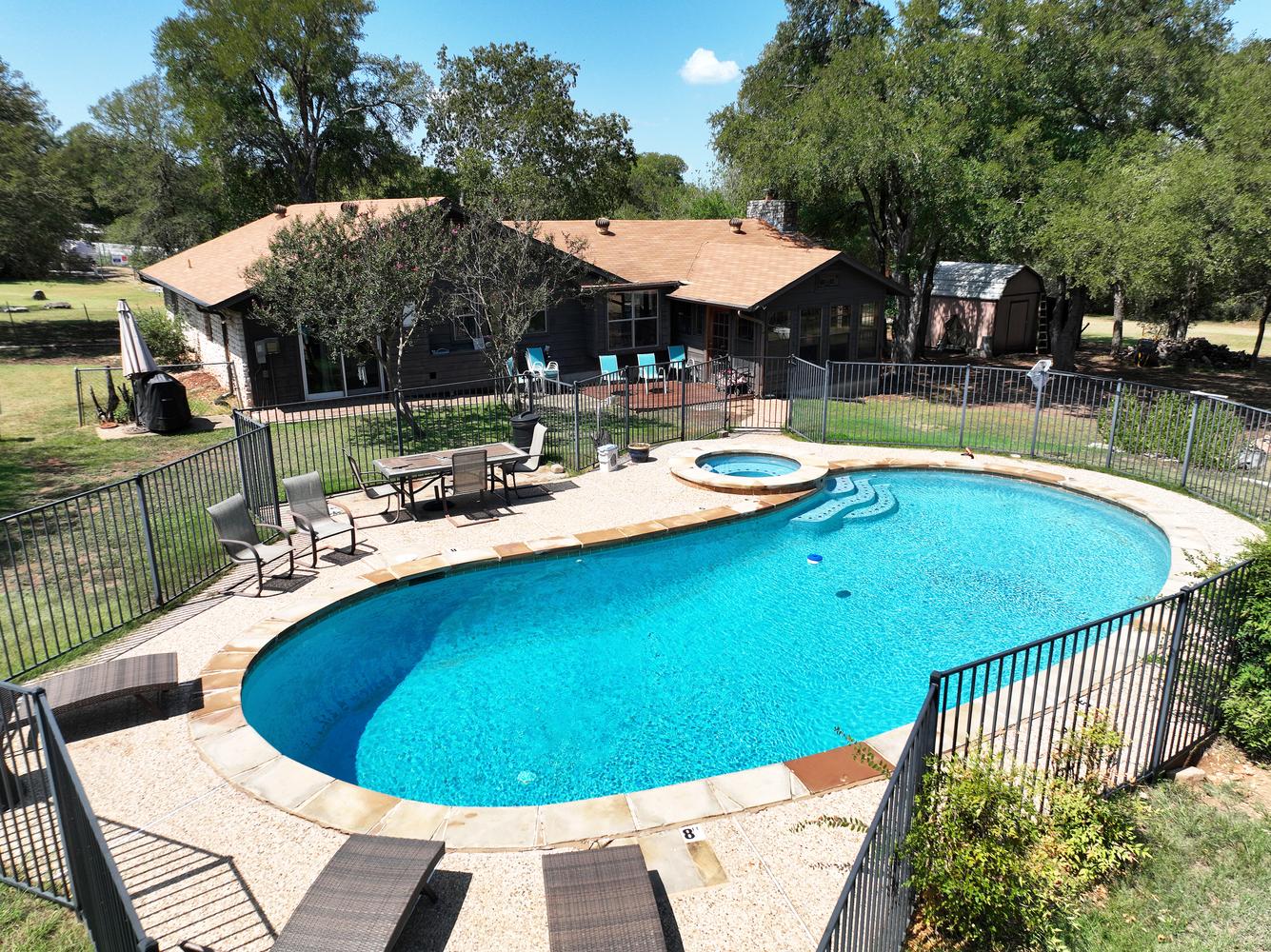2300 Robin Road Manchaca, TX 78652 - Photo 33 of 36 A sparkling swimming pool and integrated spa highlight this private backyard oasis surrounded by mature trees.