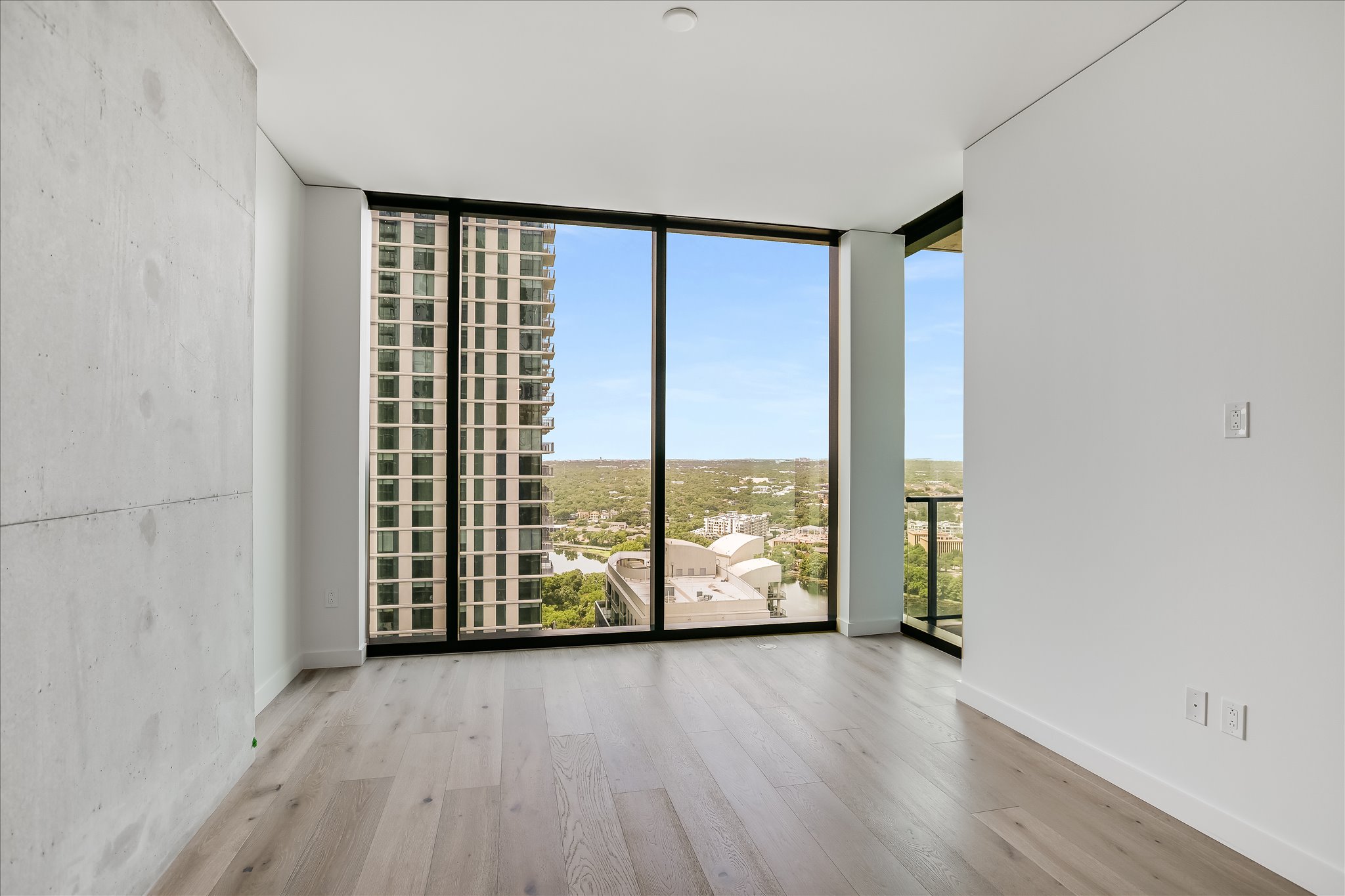 610 Davis Street, Unit 2705 Austin, TX 78701 - Photo 9 of 33 an empty room with wooden floor and windows