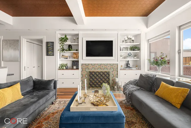 a living room with furniture a fireplace and a flat screen tv