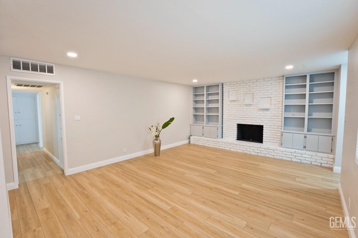 Undisclosed Address Bakersfield, CA 93304 - Photo 3 of 20 a view of empty room with wooden floor and fireplace
