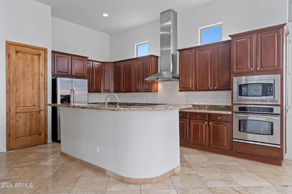 a kitchen with stainless steel appliances granite countertop a refrigerator stove and cabinets