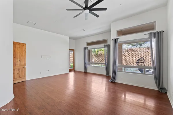 a view of an empty room with a window and wooden floor