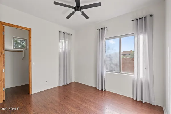 a view of empty room with wooden floor and window