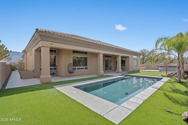 a view of a house with swimming pool and a yard
