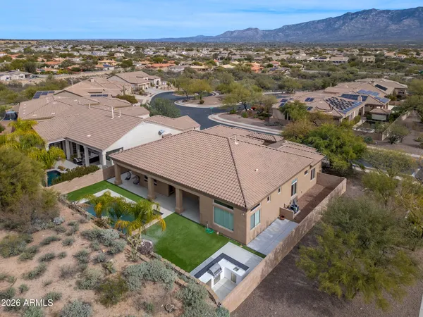 an aerial view of residential houses with outdoor space and trees