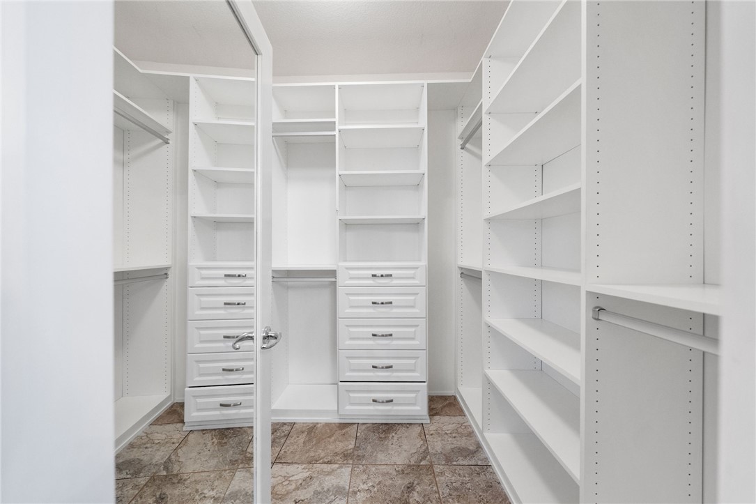 31465 Inverness Court Temecula, CA 92591 - Photo 41 of 75 Primary walk-in closet #2: spacious primary walk-in closet features mirrored doors, a combination privacy lock, soft-close drawers, abundant built-in shelving and generous hanging space for exceptional storage and organization.