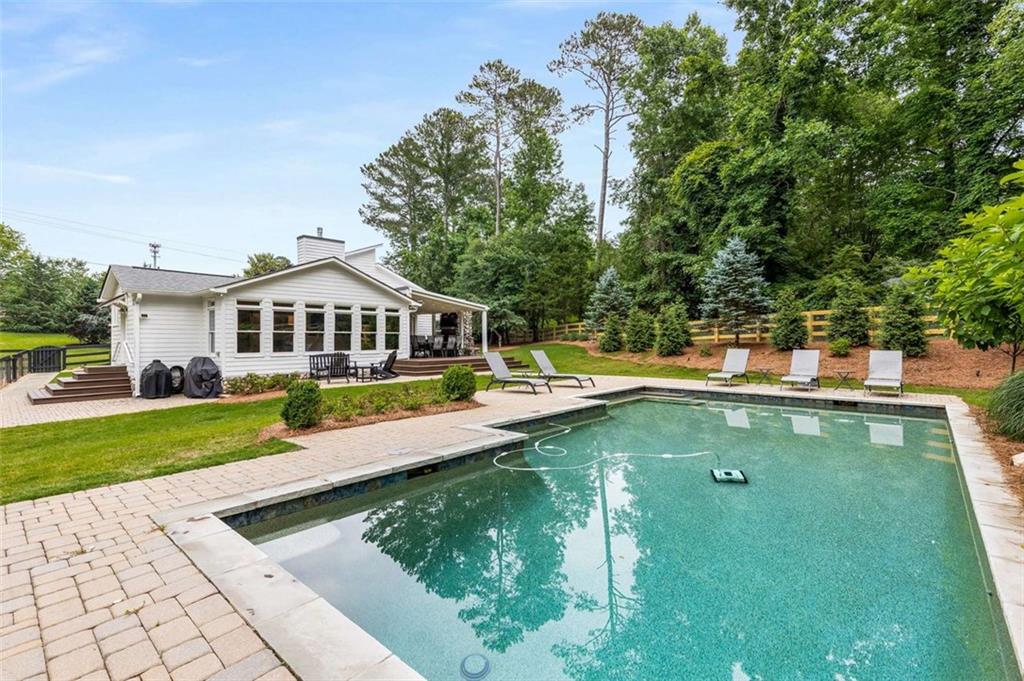 a view of an house with swimming pool and yard
