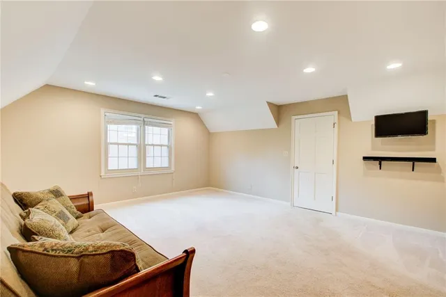 a view of an empty room with wooden floor and a fireplace