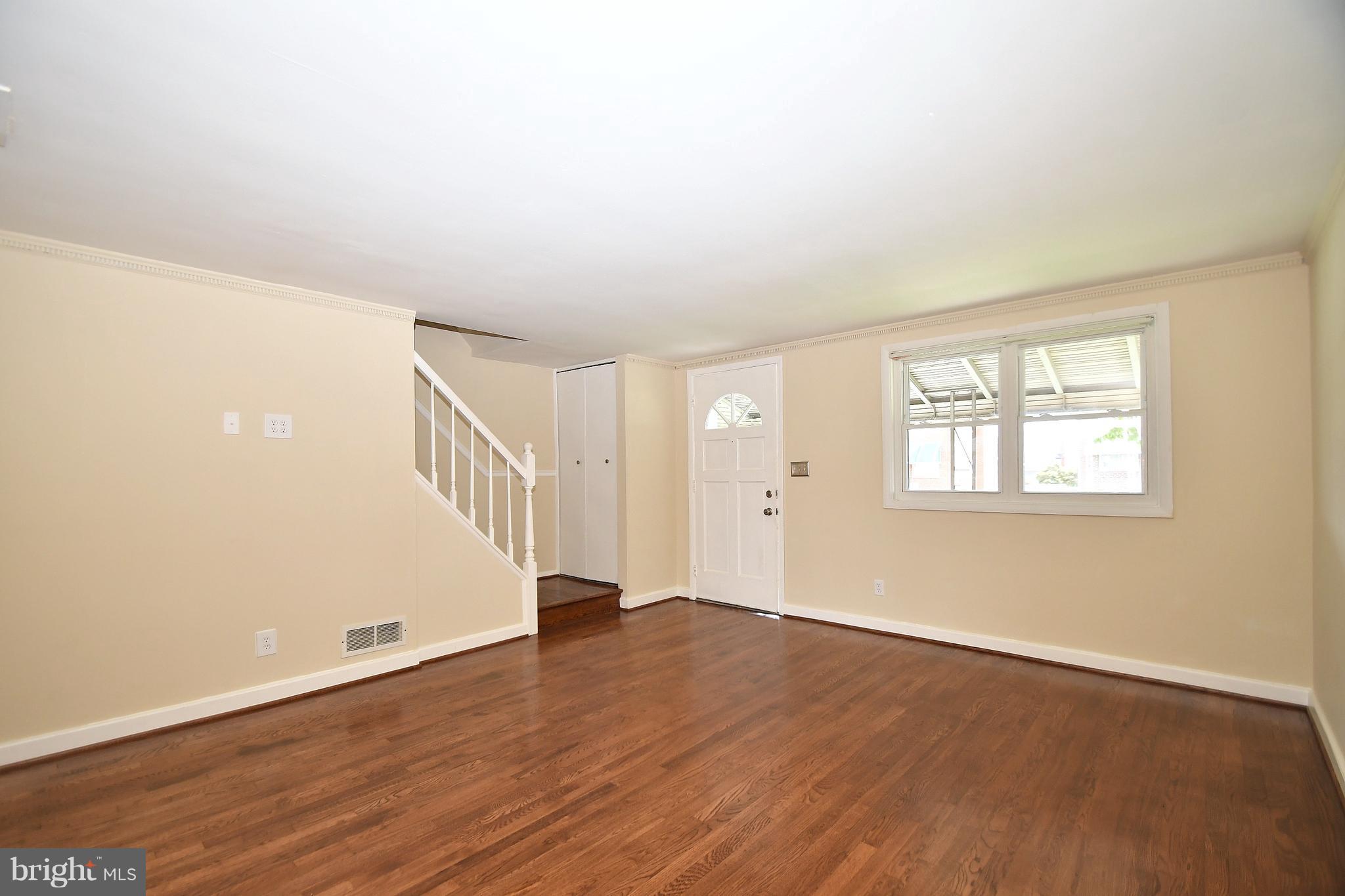 7826 Kentley Road Dundalk, MD 21222 - Photo 3 of 21 a view of an empty room with wooden floor and a window