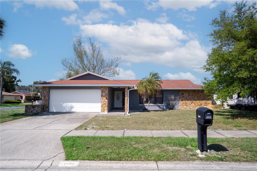 12161 100th Avenue Seminole, FL 33772 - Photo 1 of 34 a front view of a house with a yard and garage