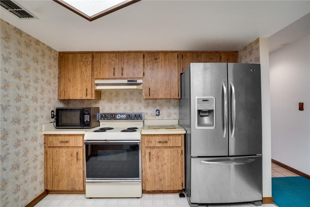 12161 100th Avenue Seminole, FL 33772 - Photo 11 of 34 a kitchen with a stove top oven and refrigerator