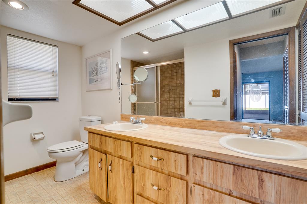 12161 100th Avenue Seminole, FL 33772 - Photo 16 of 34 a bathroom with a granite countertop sink toilet and mirror