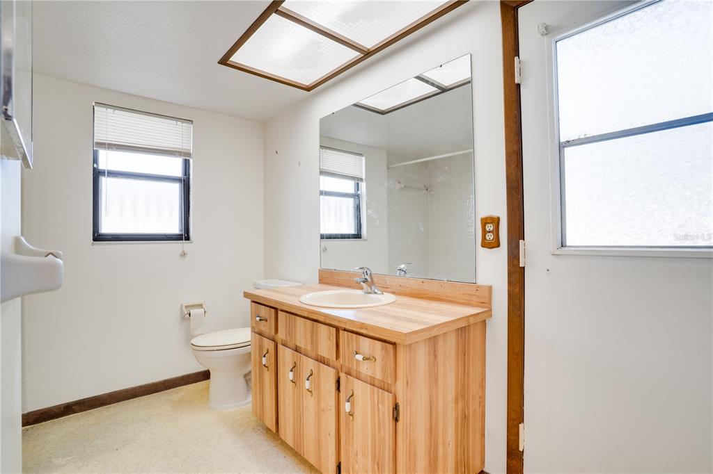 12161 100th Avenue Seminole, FL 33772 - Photo 19 of 34 a bathroom with a sink a toilet and mirror