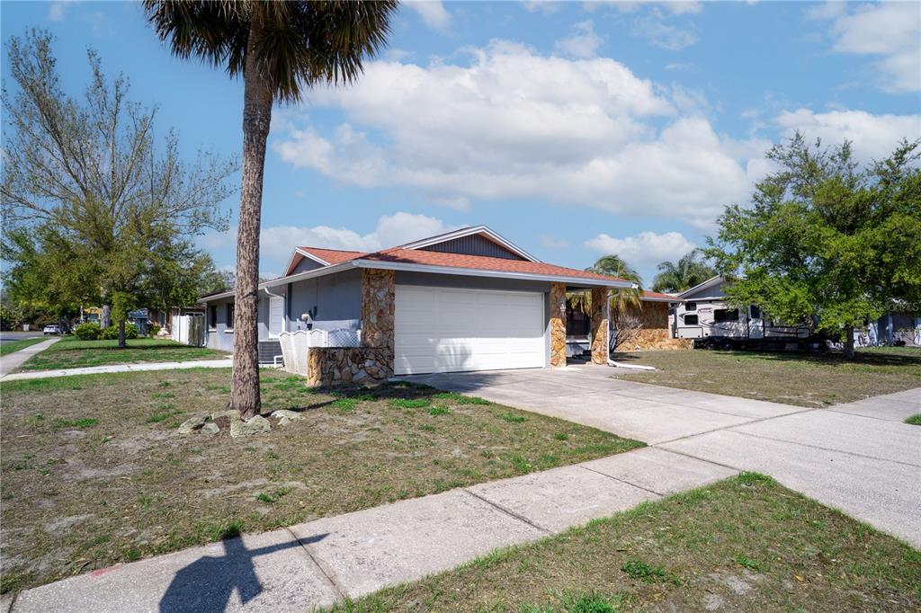 12161 100th Avenue Seminole, FL 33772 - Photo 2 of 34 a front view of a house with a garden and trees