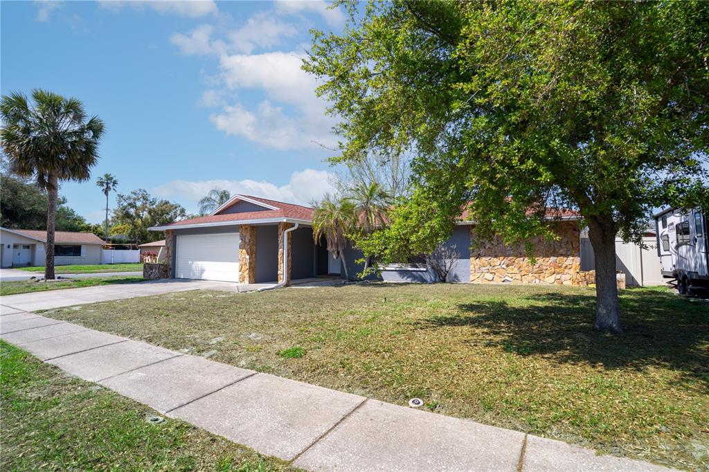 12161 100th Avenue Seminole, FL 33772 - Photo 3 of 34 a front view of a house with a yard and garage