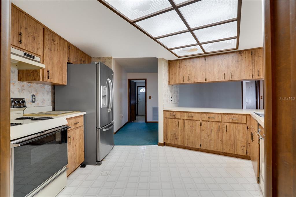 12161 100th Avenue Seminole, FL 33772 - Photo 10 of 34 a kitchen with stainless steel appliances granite countertop a stove and a refrigerator