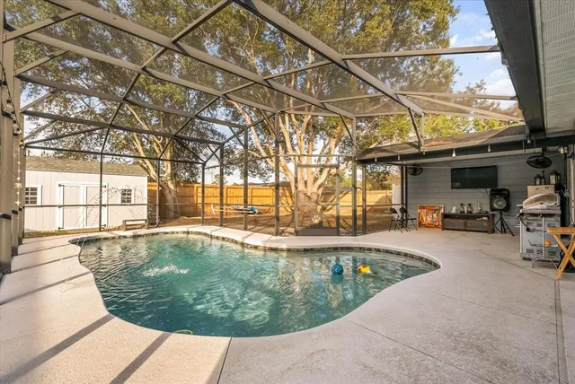 a view of a swimming pool with a patio and a tub