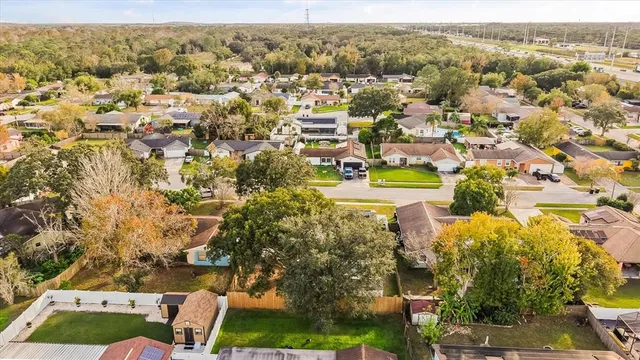 an aerial view of residential houses with outdoor space and trees