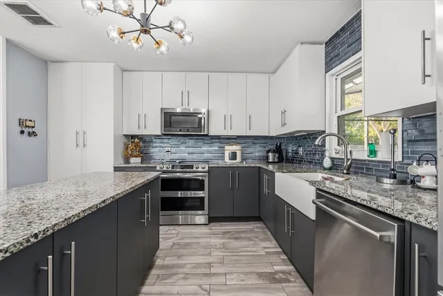 a kitchen with kitchen island granite countertop a sink a counter top space appliances and cabinets
