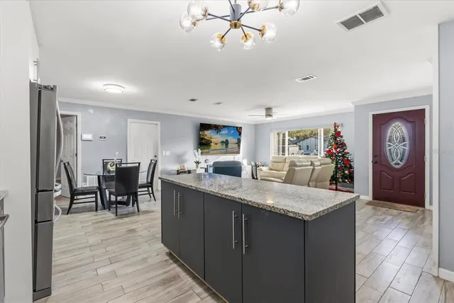 a living room with granite countertop furniture a dining table chairs and a chandelier