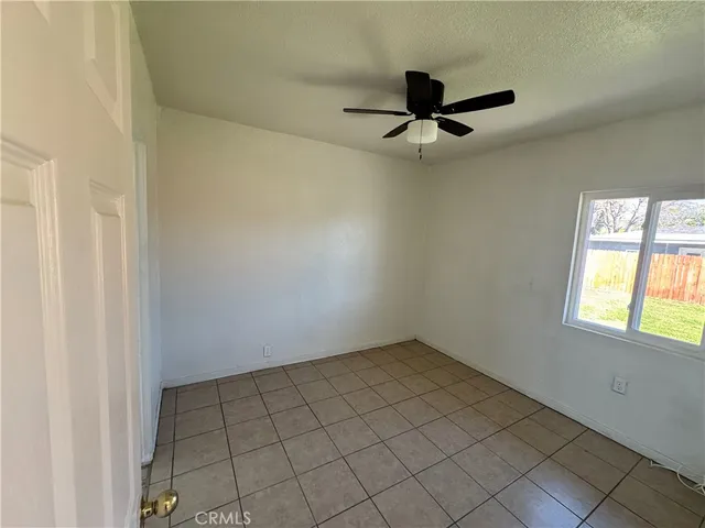 an empty room with windows and fan