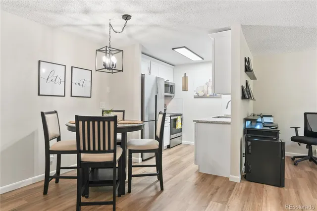 a view of a dining room with furniture wooden floor and a chandelier
