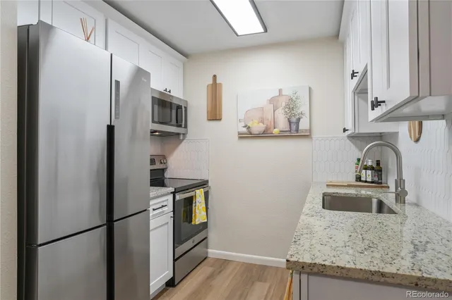 a kitchen with stainless steel appliances granite countertop a refrigerator and a sink