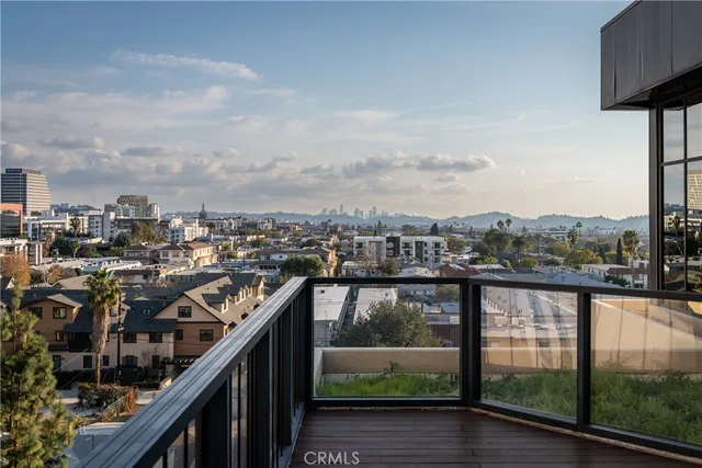 a view of a hallway with wooden floor and a livingroom