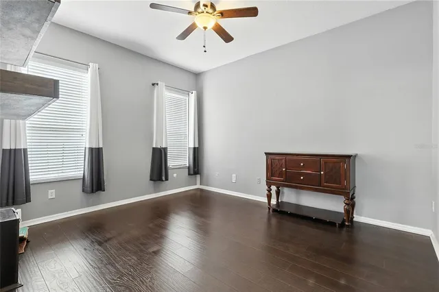 a view of room with wooden floor and ceiling fan