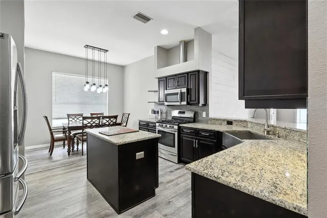 a kitchen with a stove sink and cabinets