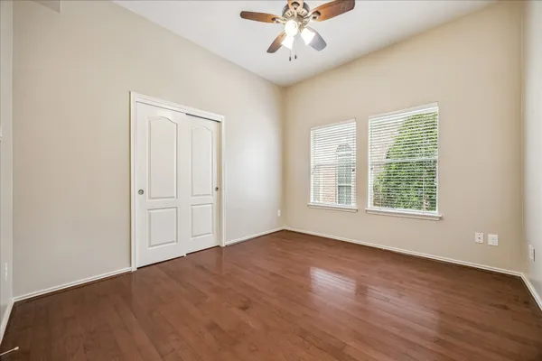 a view of an empty room with a window and wooden floor