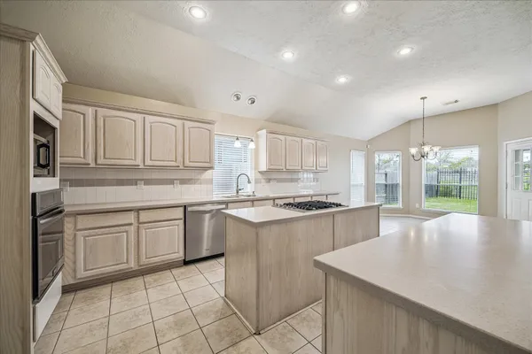 a kitchen with white cabinets and sink