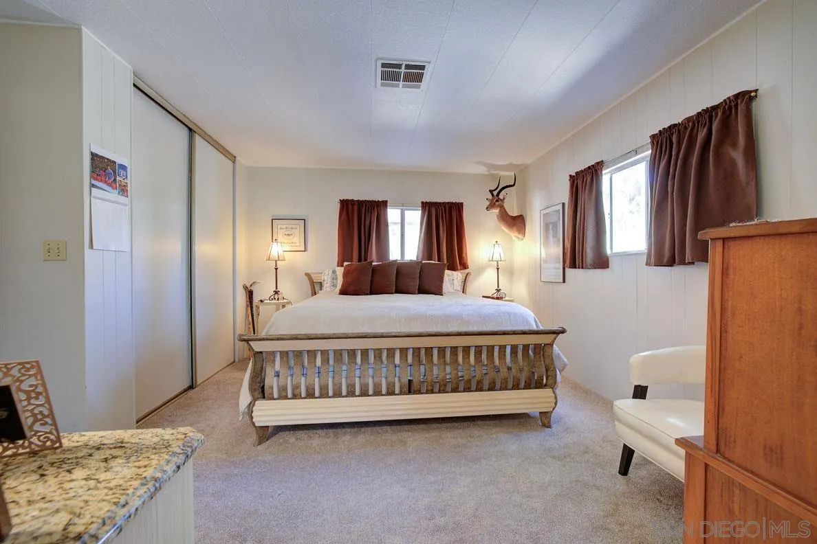 31050 Lilac Road Valley Center, CA 92082 - Photo 18 of 35 a spacious bedroom with a bed a window and dresser
