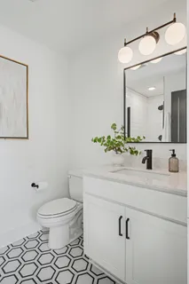 a bathroom with a sink mirror vanity and toilet